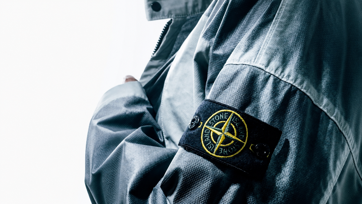 Badge boussole Stone Island cousu sur la manche, symbole de la marque