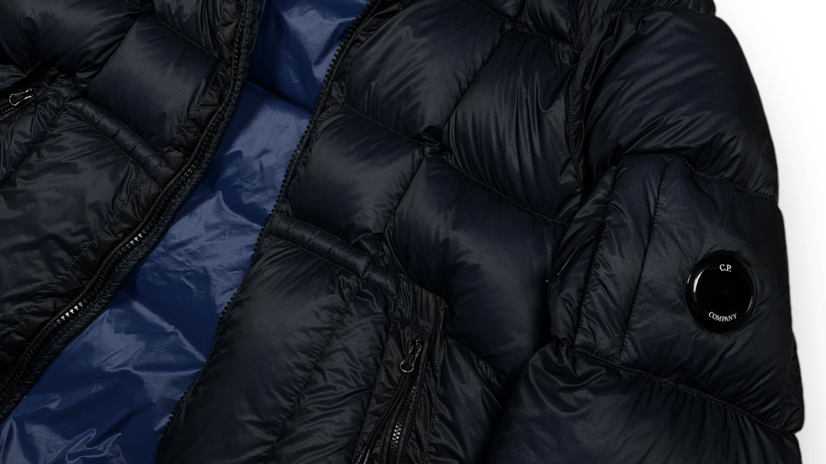 Detail of a navy C.P Company D.D Shell down jacket, a model sought after on the resale market
