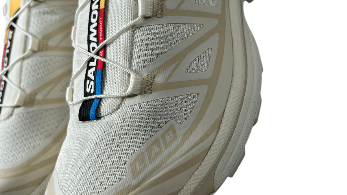 Logo Salomon en gros plan sur une sneaker crème authentifiée chez NB08