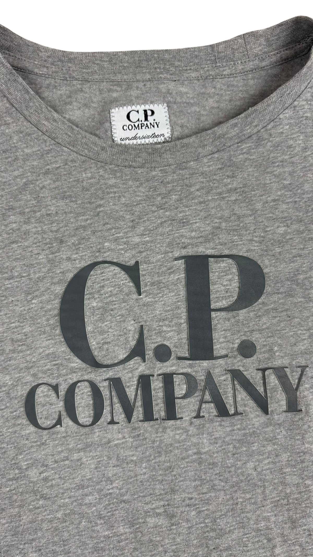 Détail du logo C.P Company imprimé sur l'avant et étiquette encolure C.P Company undersixteen du tee-shirt gris