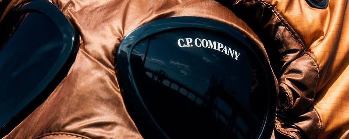 Lentille C.P Company orange en gros plan, repère d'authenticité en seconde main
