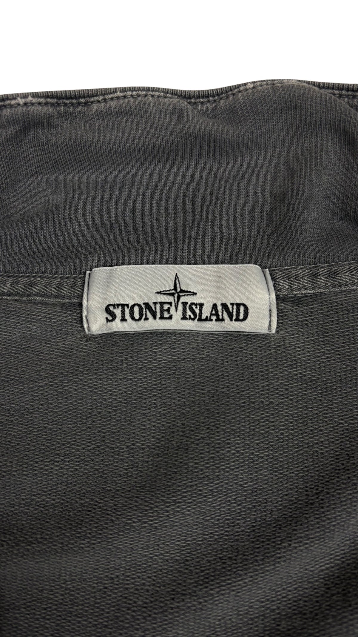 Etiquette de marque Stone Island cousue a l interieur de la veste grise